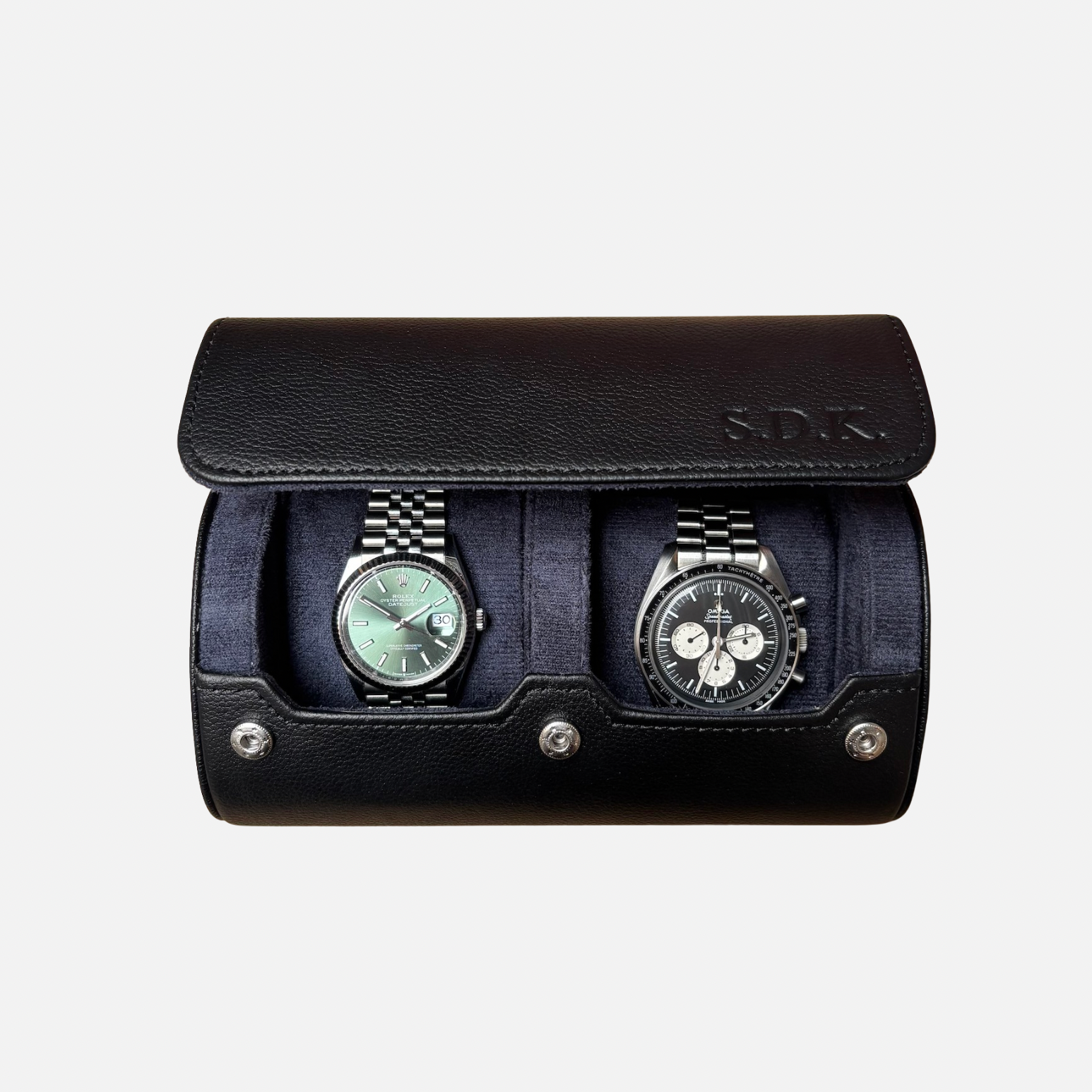 Black leather watch case with two watches on a light gray background